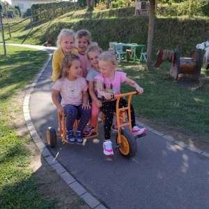 lachende Kinder auf einem Dreirad