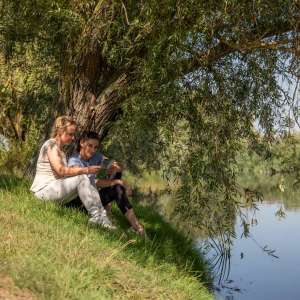 Idylle und Erholung pur 2 Frauen unter einer Weide am Ufer sitzend