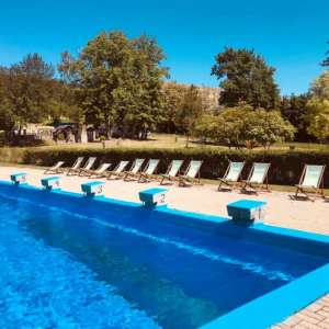Schwimmbecken mit Startblöcken und Liegestühlen im Hintergrund